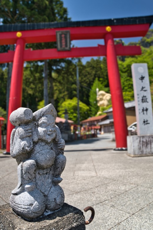 赤い鳥居の前で、小さな大黒様が旅人を迎えていた